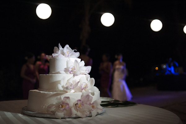 circular, tiered, white wedding cake with orchid accents - photo by Hawaii based wedding photographer Derek Wong